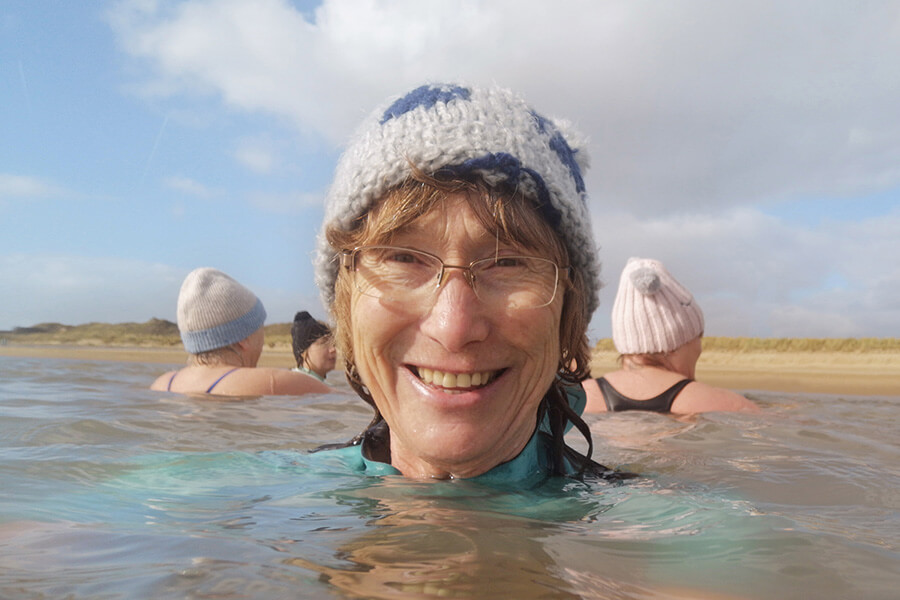 woman swimming wearing a woolly hat